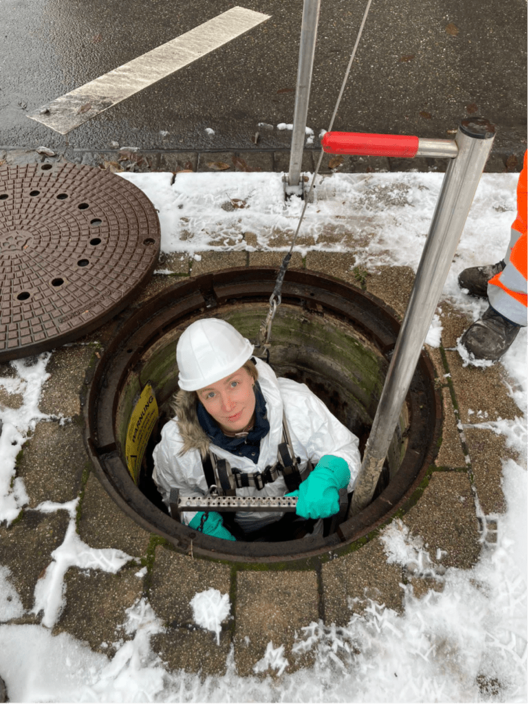 Mitarbeiterin des IWR führt Leiterprüfung in Kanalschacht durch